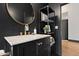 Stylish bathroom features black walls and a marble topped vanity with a modern round mirror at 118 W Palm Ln, Phoenix, AZ 85003