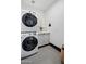 Well-lit laundry room featuring a stacked washer and dryer and stylish hexagonal tile flooring at 118 W Palm Ln, Phoenix, AZ 85003