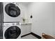 A laundry room with stacked washer/dryer, gray cabinetry, and modern gray hexagonal tile flooring at 118 W Palm Ln, Phoenix, AZ 85003