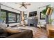 Cozy living room with fireplace, ceiling fan, TV, and natural light from large windows at 118 W Palm Ln, Phoenix, AZ 85003