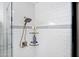 Close-up of a modern shower with white subway tile, glass shelves, and chrome fixtures at 118 W Palm Ln, Phoenix, AZ 85003