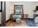 Bedroom sitting area with a patterned chair, ottoman, side table, and window at 118 W Palm Ln, Phoenix, AZ 85003