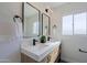 Bathroom featuring a stylish double vanity with quartz countertop, modern fixtures, and sleek mirrors at 1215 E Cambridge Ave, Phoenix, AZ 85006