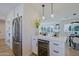 Modern kitchen with stainless steel fridge, wine cooler and quartz countertops, blending into an open concept living area at 1215 E Cambridge Ave, Phoenix, AZ 85006