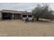 Landscaped backyard featuring mature trees, patio cover, and neutral stone ground cover with a patio seating area at 12236 N Pebble Beach Dr, Sun City, AZ 85351