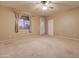 Spacious carpeted bedroom with a ceiling fan, door, and large window at 12326 N Lang Rd, Florence, AZ 85132