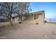 A neutral-toned home with a tile roof and gravel landscaping, framed by a large shade tree at 12326 N Lang Rd, Florence, AZ 85132