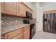 Bright kitchen with wooden cabinets, black appliances, and a tile backsplash for a modern and clean cooking space at 12326 N Lang Rd, Florence, AZ 85132