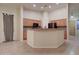 Open kitchen area featuring tile flooring, wood cabinetry, and a breakfast bar for casual dining and entertaining at 12326 N Lang Rd, Florence, AZ 85132