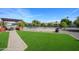 Expansive backyard with artificial grass, mature landscaping, and a pergola at 13207 N Lakeforest Dr, Sun City, AZ 85351