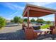 Backyard with a gazebo structure, gravel landscaping, and built-in benches offer an inviting outdoor living space at 13207 N Lakeforest Dr, Sun City, AZ 85351