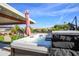 Backyard featuring a hot tub under a covered patio, along with outdoor furniture and well-maintained landscaping at 13207 N Lakeforest Dr, Sun City, AZ 85351