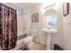 Well-maintained bathroom featuring a pedestal sink, neutral color scheme, and shower with modern curtain at 15712 W Eucalyptus Ct, Surprise, AZ 85374