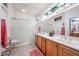 Bright bathroom featuring dual sinks, a glass shower, and updated fixtures at 15712 W Eucalyptus Ct, Surprise, AZ 85374