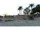 Stone community sign surrounded by desert landscaping and palm trees against a bright sky at 15712 W Eucalyptus Ct, Surprise, AZ 85374