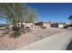 A single story home featuring gravel landscaping, desert foliage, and a tile roof on a clear day at 15712 W Eucalyptus Ct, Surprise, AZ 85374