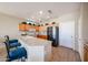 Well-lit kitchen with wood cabinets, black appliances, a breakfast bar, and decorative plants at 15712 W Eucalyptus Ct, Surprise, AZ 85374