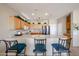 Bright kitchen featuring light wood cabinets, a breakfast bar with seating, and modern appliances at 15712 W Eucalyptus Ct, Surprise, AZ 85374