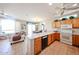 Kitchen with oak cabinets, a breakfast bar, modern appliances, and an open view to the living spaces at 15712 W Eucalyptus Ct, Surprise, AZ 85374