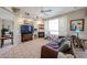 Cozy living room featuring tile floors, a fireplace, and bright windows with plantation shutters at 15712 W Eucalyptus Ct, Surprise, AZ 85374