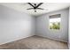 Bedroom featuring neutral carpet, ceiling fan, and a large window at 16074 W Cortez St, Surprise, AZ 85379