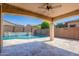 Covered patio with ceiling fan overlooks a serene pool and backyard at 16074 W Cortez St, Surprise, AZ 85379