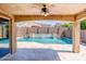 Covered patio with a ceiling fan offering serene views of the pool and backyard at 16074 W Cortez St, Surprise, AZ 85379