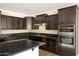 Close-up of kitchen featuring stainless steel appliances and dark granite countertops at 16074 W Cortez St, Surprise, AZ 85379