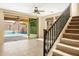 Bright living room with tile floors, stairs, and sliding glass doors to the pool at 16074 W Cortez St, Surprise, AZ 85379