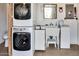 Bright laundry room with a stacked washer and dryer unit and a utility sink at 17200 W Bell Rd # 845, Surprise, AZ 85374