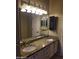 Bathroom vanity with double sinks, granite countertop, and ample lighting at 1734 E Commonwealth Cir, Chandler, AZ 85225