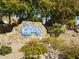 Stone community sign landscaped with mature trees and desert plants at 1734 E Commonwealth Cir, Chandler, AZ 85225