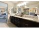 Bathroom with double sinks, dark wood cabinets, large mirrors, and modern decor at 17850 N 68Th St # 2160, Phoenix, AZ 85054