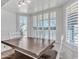 Bright dining area featuring a modern wooden table and bench seating, bathed in natural light from shuttered windows at 19061 N 5Th Ave, Phoenix, AZ 85027