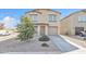 Inviting exterior of a tan two-story home with a two-car garage and drought-tolerant desert landscaping at 197 E Douglas Ave, Coolidge, AZ 85128