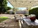 Outdoor patio with a pergola, seating, a dining table, and beautifully landscaped yard at 20315 N 82Nd Ln, Peoria, AZ 85382