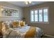 Comfortable bedroom with a sunflower-themed bed, a decorative mirror, and plantation shutters at 20315 N 82Nd Ln, Peoria, AZ 85382