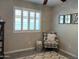 Cozy bedroom nook with a patterned chair, neutral decor, and plenty of natural light from the shuttered window at 20315 N 82Nd Ln, Peoria, AZ 85382