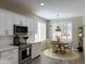 Bright kitchen featuring stainless steel appliances, white cabinetry, and a cozy dining area with shuttered windows at 20315 N 82Nd Ln, Peoria, AZ 85382