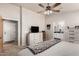 Bright bedroom with a large window, ceiling fan and view into the primary bathroom at 20438 W Carver Rd, Buckeye, AZ 85326