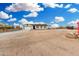 Single-story home with two-car garage surrounded by a large lot and blue skies with puffy clouds at 20438 W Carver Rd, Buckeye, AZ 85326