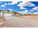 Single-story home with two-car garage, and a large lot under a blue sky filled with clouds at 20438 W Carver Rd, Buckeye, AZ 85326