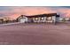 Single-story home with rustic wood fence and two-car garage, set against a vibrant sunset backdrop at 20438 W Carver Rd, Buckeye, AZ 85326