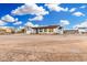 Single-story home with two-car garage and large dirt lot under a bright blue, cloudy sky at 20438 W Carver Rd, Buckeye, AZ 85326