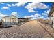 View of the exterior lot featuring a shed, covered horse stalls, and ample parking on a gravel lot at 20438 W Carver Rd, Buckeye, AZ 85326