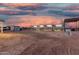 Expansive horse property with stables, an arena, and ample space for equestrian activities at sunset at 20438 W Carver Rd, Buckeye, AZ 85326