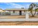 Charming single-story home with a white exterior, a dark front door, and a fenced front yard at 2053 W Pecan Rd, Phoenix, AZ 85041