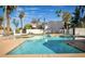 Beautiful community pool surrounded by trees with sun loungers in a pleasant, sunny setting with clear blue skies at 2140 E Rosarita Dr, Tempe, AZ 85281