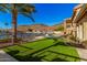 Lush backyard features artificial grass, a large palm tree, and a waterfront view with mountain backdrop at 21666 N 53Rd Dr, Glendale, AZ 85308