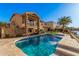 Exterior view of a two-story home with a swimming pool, balcony, manicured lawn, and waterfront access at 21666 N 53Rd Dr, Glendale, AZ 85308